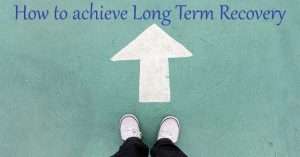 feet standing at an arrow pointing towards a sign that reads how to achieve long term recovery