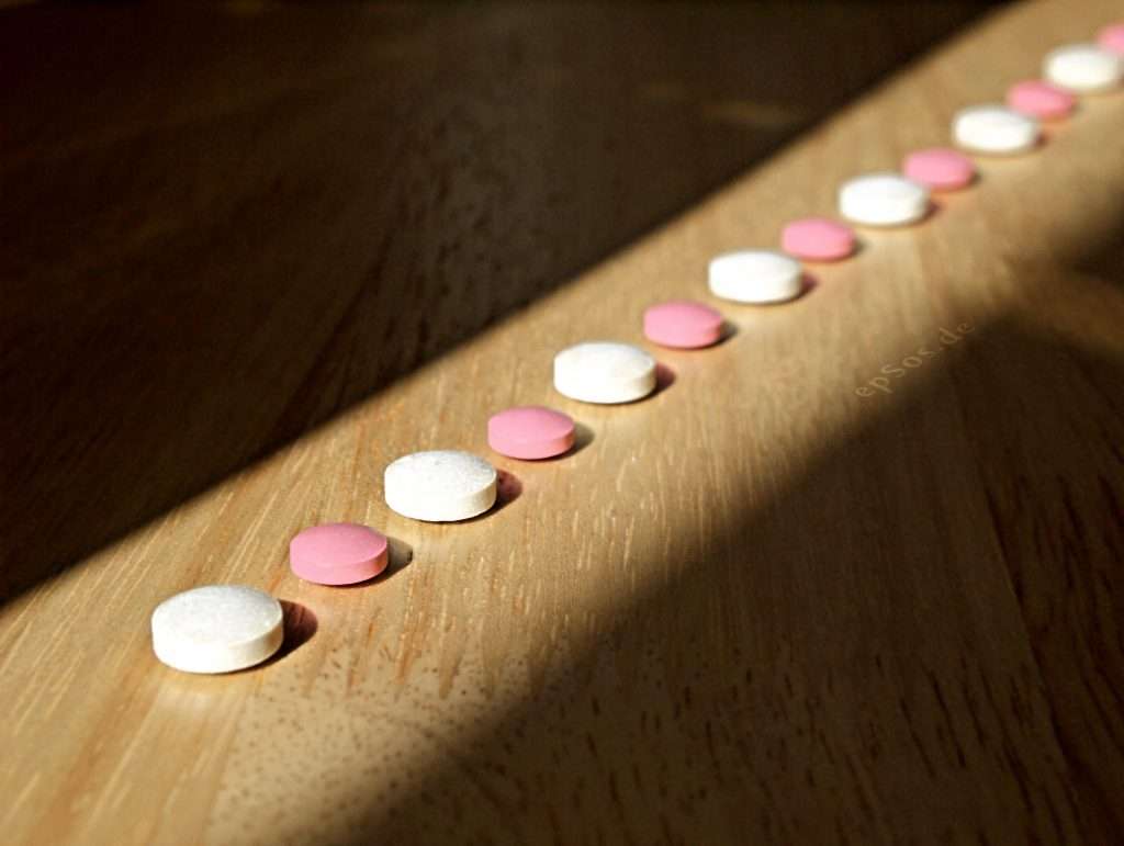 line of pills demonstrating drug addiction