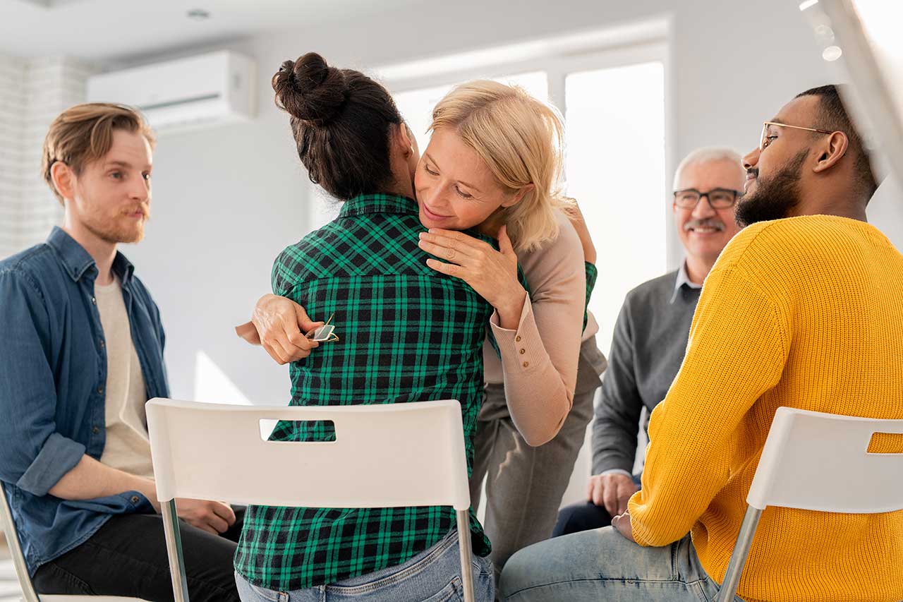 Two Woman Hug at a Support Group Meeting at our inpatient addiction treatment center