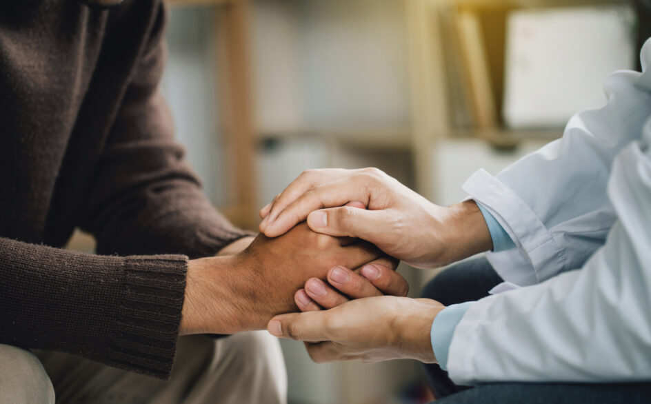 Close-up of psychiatrist hands together holding palm of her patient. comforts an anxious depression patient for medical treatment in diagnostic room, PTSD Mental health concept