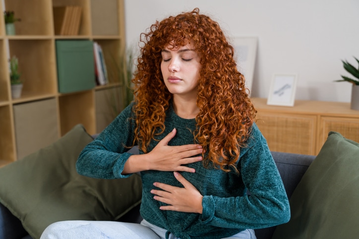 Woman practicing diaphragmatic breathing at home