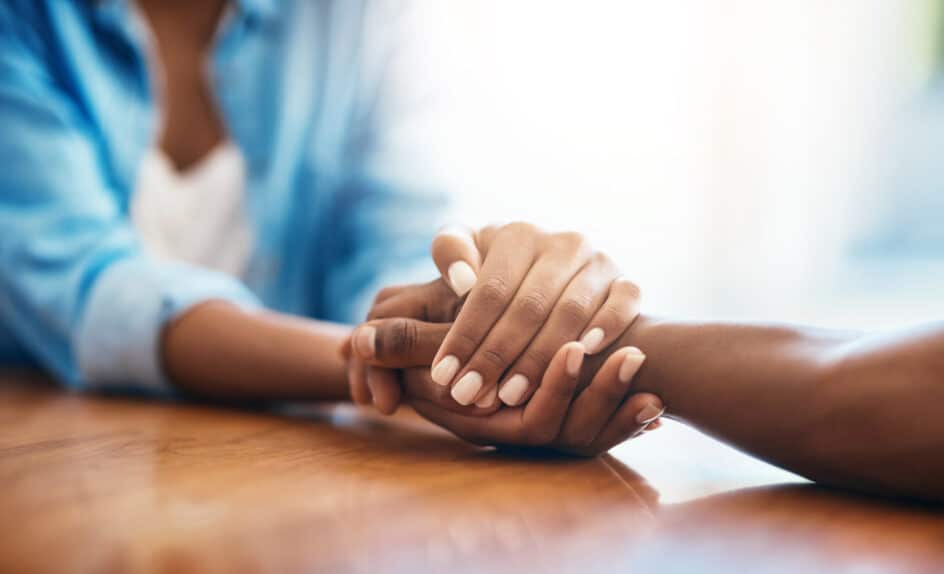Addiction Treatment counselor holding the hands of patient going through drug rehabilitation treatment